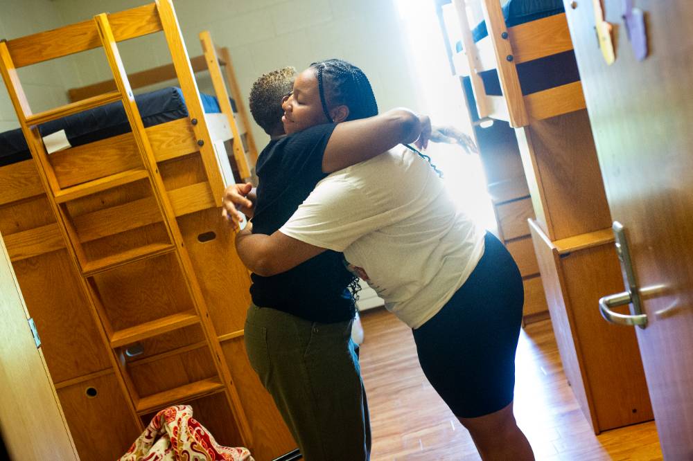 An incoming freshman hugging her mom while moving in.